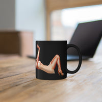 Pin-up Girl Lying On Her Back Printed On A Black Coffee Mug On a Table With A Laptop